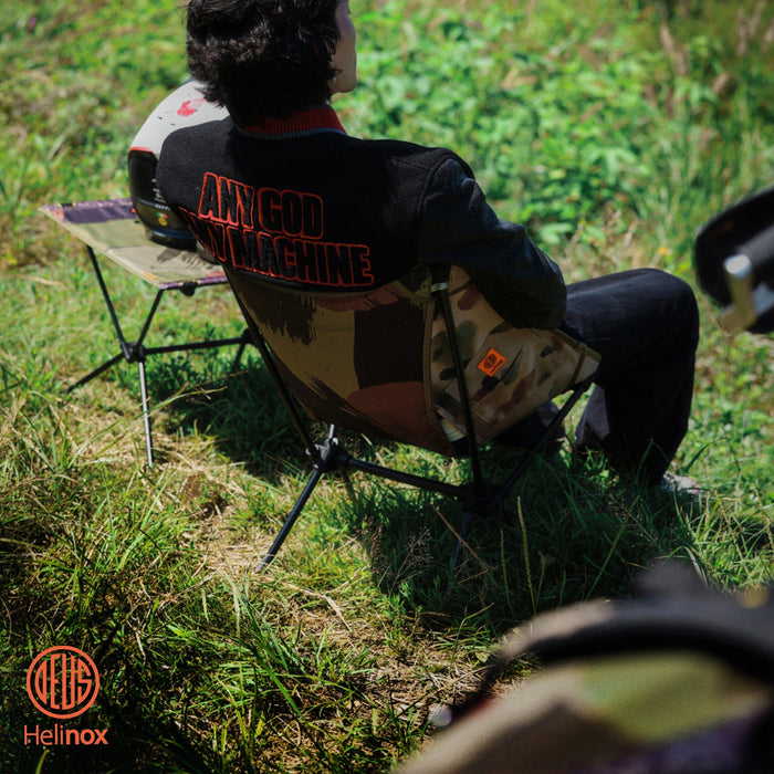 A man sitting in a portable camp chair on the grass