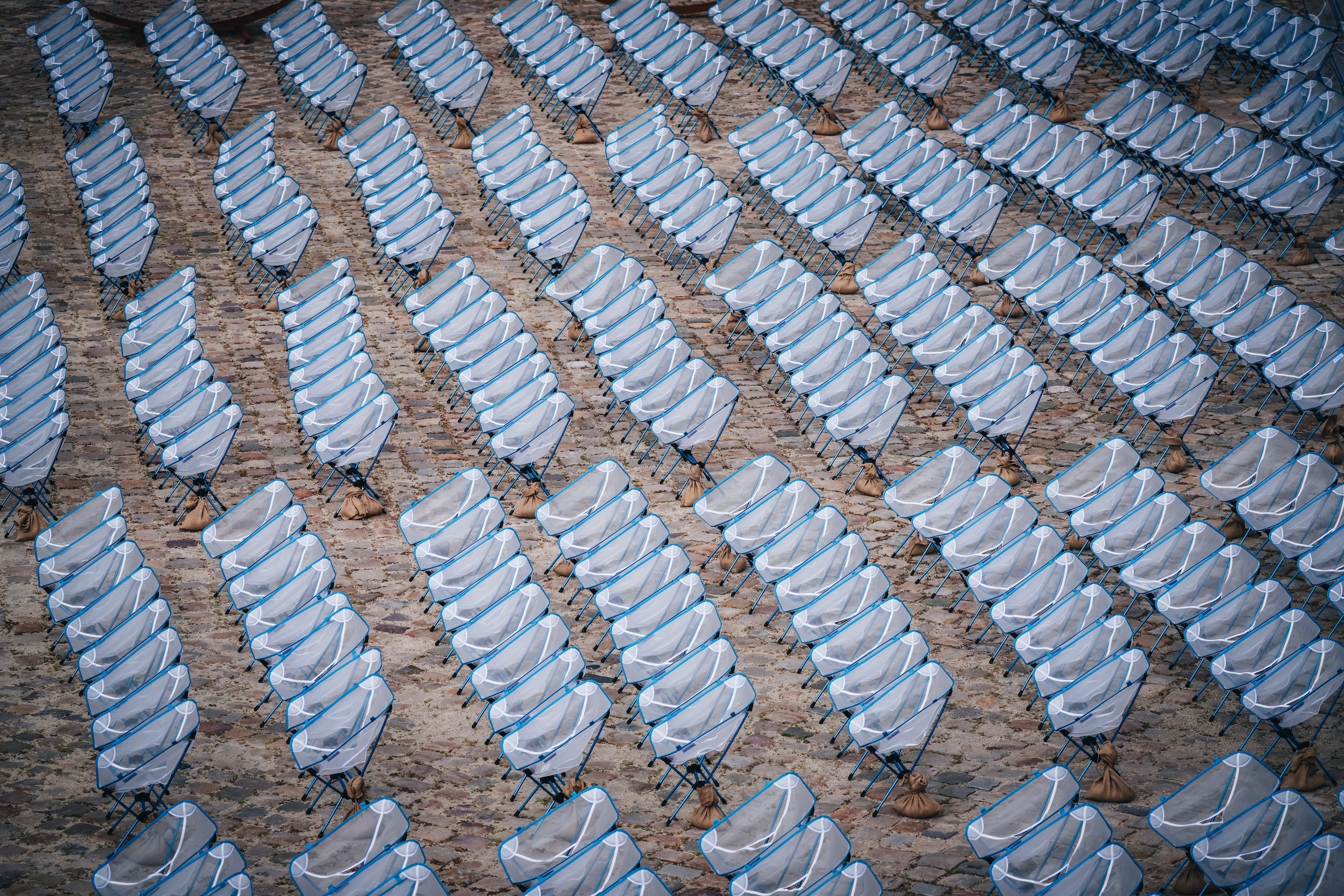 An overhead view of many lightweight camping chairs set up in rows.