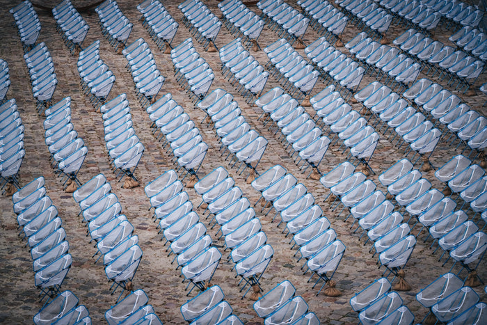 An overhead view of many lightweight camping chairs set up in rows.