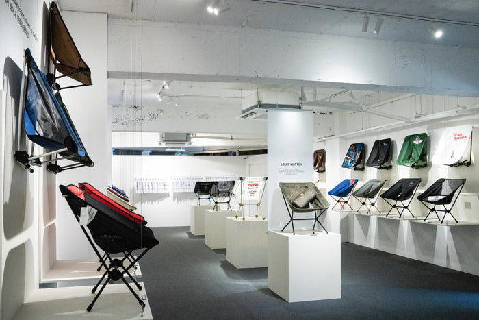 An exhibition gallery displaying various models of lightweight camping chairs.